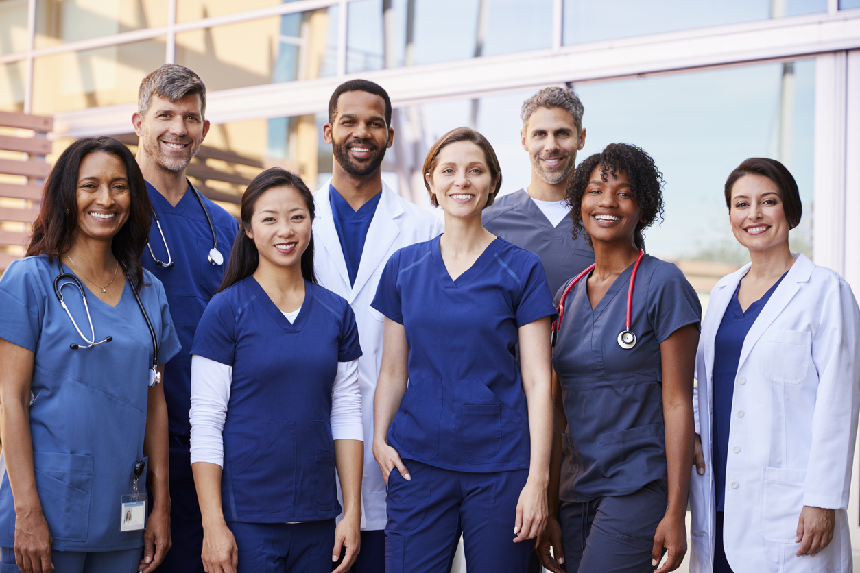 smiling medical team standing together outside a hospital